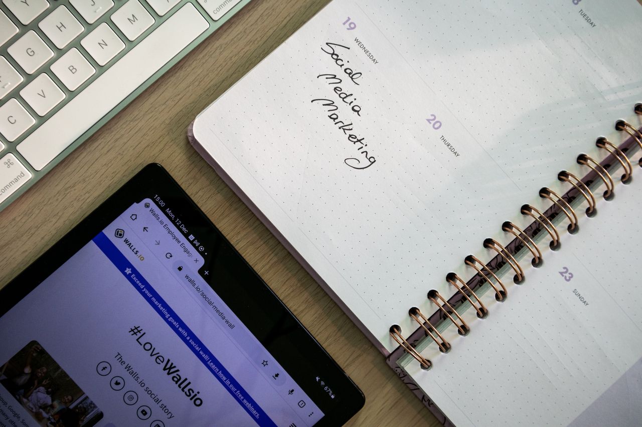 hero-img Overhead view of a notebook, tablet, and keyboard being used to plan social media marketing.